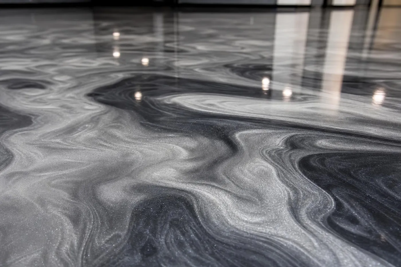 Close-up of a finished metallic epoxy floor with pearlescent silver and charcoal swirl, installed in Memphis TN